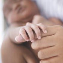 photo of Black mother holding infant's hand